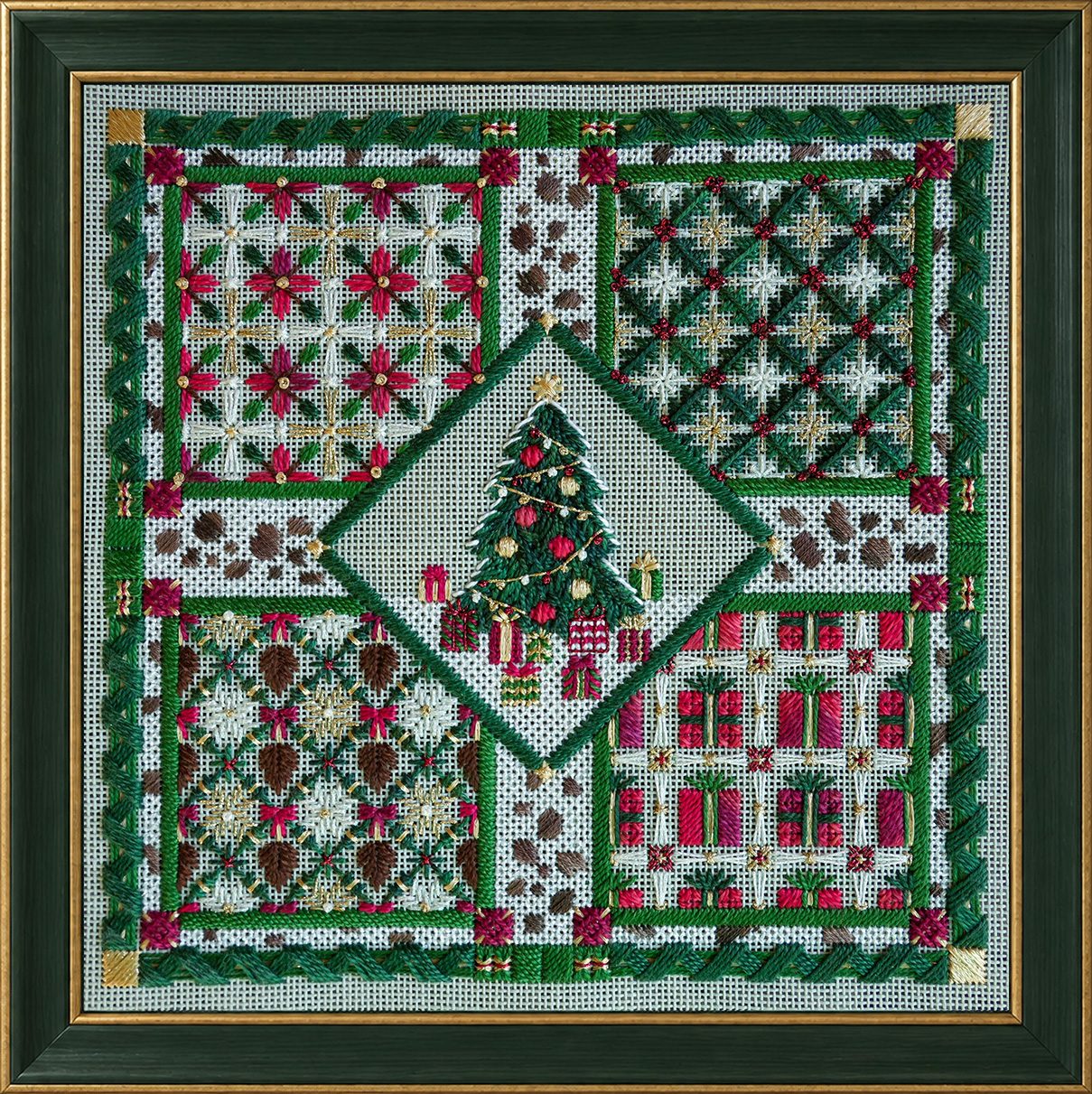 Framed finished needlepoint of Very Merry Garden, a Christmas counted canvas design with a decorated tree, four garden trellis panels, poinsettias, wrapped presents and snowflakes in red, green, white and gold.